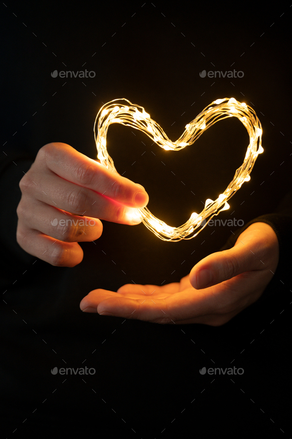 Hand holding heart made from lights - Stock Photo - Images