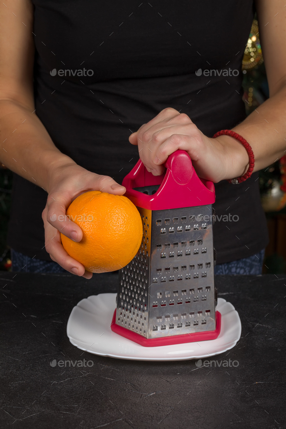 Chef rubs orange peel close-up in the kitchen