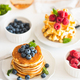 Homemade baked ricotta pancakes and Belgian waffles with fresh berries on white wooden table - PhotoDune Item for Sale