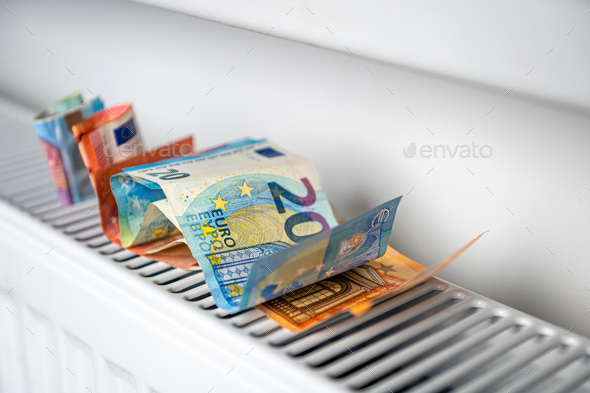 euro banknotes in a central heating radiator, the concept of expensive heating costs, closeup - Stock Photo - Images