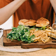 Cropped closeup man male sitting in front of sliced grilled tasty beefy cheese burger hamburger and - PhotoDune Item for Sale