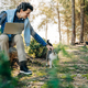 Happy cheerful man with a laptop sitting outdoors on rock in nature forest park and pet cat - PhotoDune Item for Sale