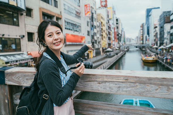 woman pointing at cruise ship on doutonbori river