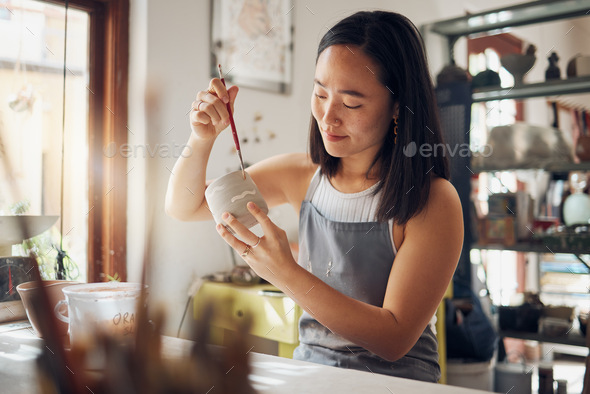 Pottery, art and design with an asian woman in a studio for her creative ceramics hobby as an artis