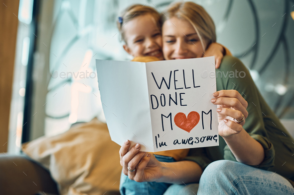 Close-up of woman receiving greeting card from her daughter on Mother\'s day.