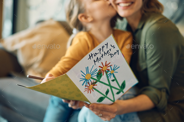 Close-up of woman receiving Mother's day greeting card from her daughter.