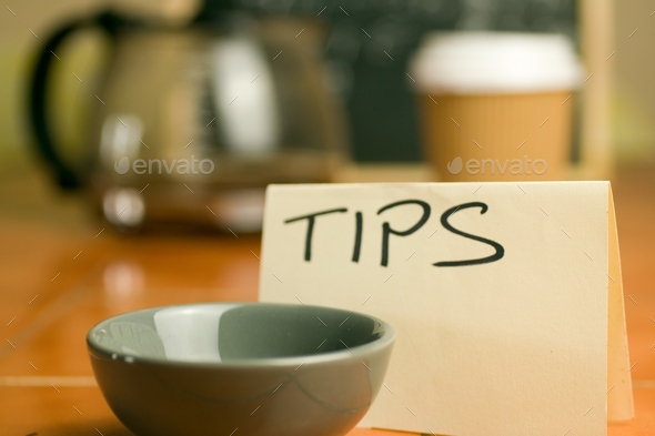 Tip jar in cafe with coffee background