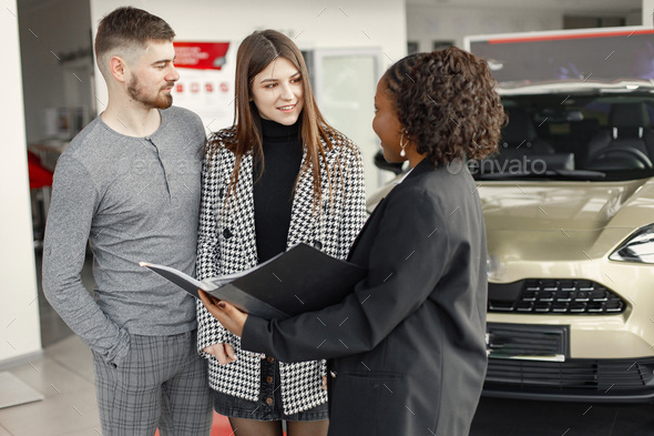 Young couple with a sales agent is going to buy a car - Stock Photo - Images