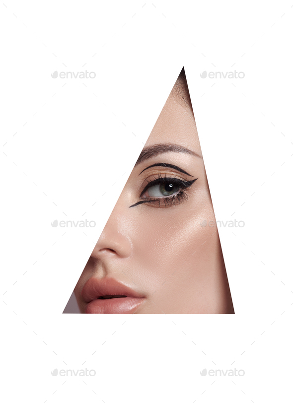 Beauty makeup women, eye brows eyelashes and lips in a triangular hole paper white background