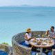 couple having lunch at an restaurant looking out over the ocean of Pattaya Thailand, man and woman - PhotoDune Item for Sale