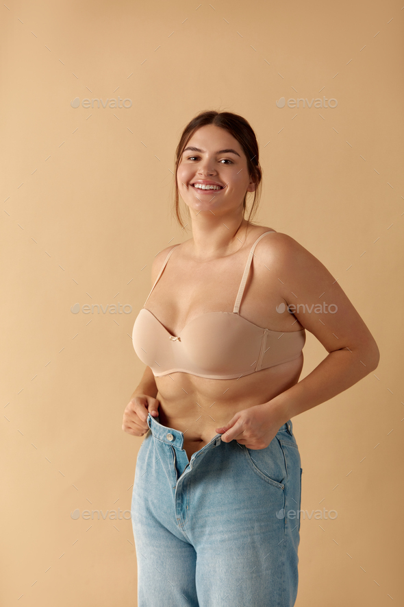 Plus Size Woman in Jeans. Overweight Smiling Woman Demonstrating