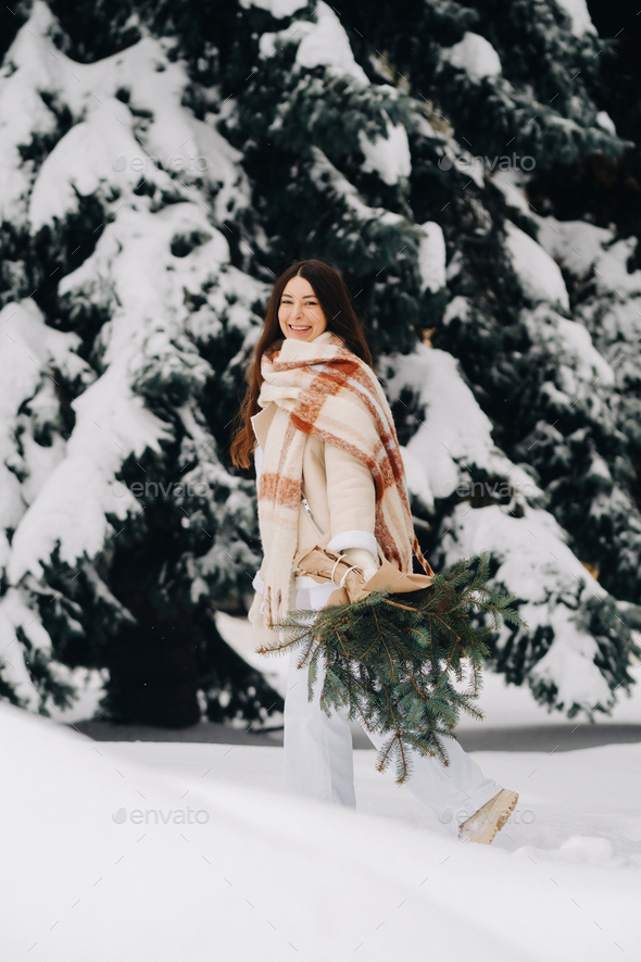 A girl in a winter forest with a bouquet of fir branches. Snowy winter - Stock Photo - Images