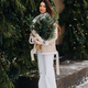 A girl with long hair in winter on the street with a bouquet of fresh fir branches - PhotoDune Item for Sale