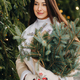 A girl with long hair in winter on the street with a bouquet of fresh fir branches - PhotoDune Item for Sale