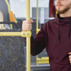 Young man with beard wearing khudi, standing on bus, holding backpack, looking forward. - PhotoDune Item for Sale