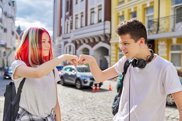 Teenage boy and girl meeting, greeting with hands
