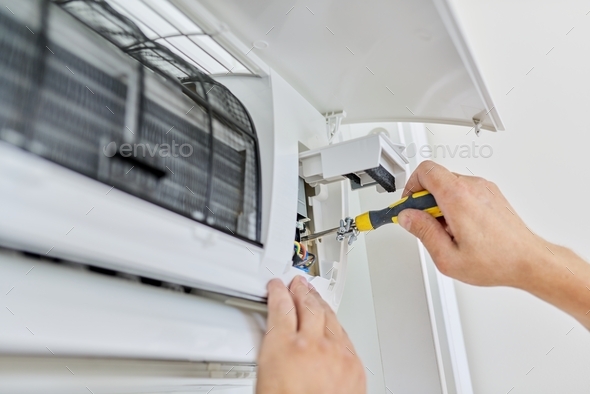 Installing an air conditioner in an apartment office, close-up of an engineer hand