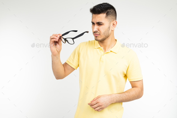 guy has dry eyes taking off glasses on a white background