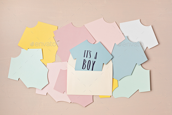 Baby shower, gender reveal party. It\'s a boy message over paper cut onesie