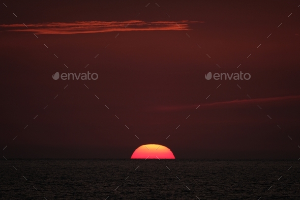 Beautiful shot of the sun going down in a red sky - Stock Photo - Images