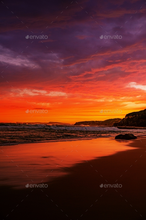 Vertical shot of calm sea waves moving towards the shore during a ...