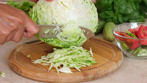 Woman hands cut fresh cabbage to make salad, homemade food.