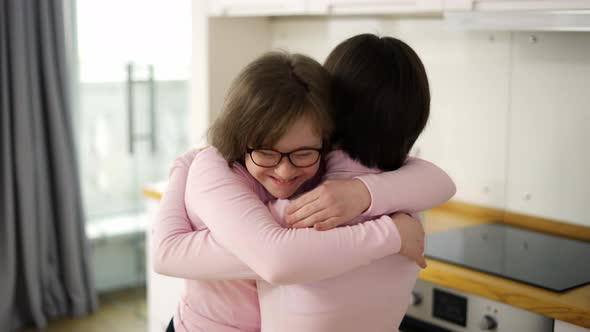 Happy Girls with Down Syndrome Come Together to Hug alt