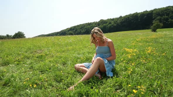 Young Pregnant Woman Enjoying Summer Day in Meadow