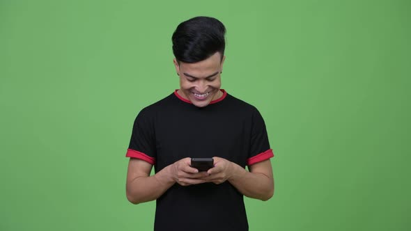 Young Happy Multiethnic Man Thinking While Using Phone