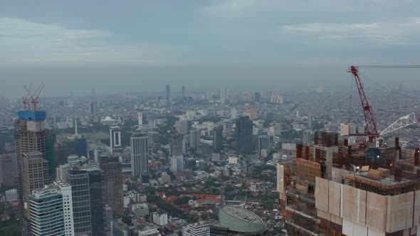 Aerial Dolly Shot Passing the Top of the Skyscraper Under Construction Flying Towards Buildings in alt
