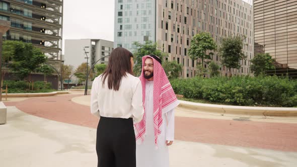 Smiling Arab Businessman Greeting Female Business Partner Meeting Outdoors for Contract Negotiations alt