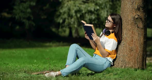 Woman Reading Book Under Tree in Park