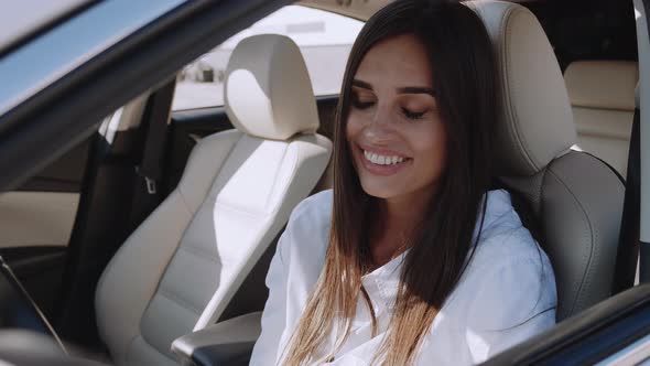 Young Smiling Woman Sitting in Automobile