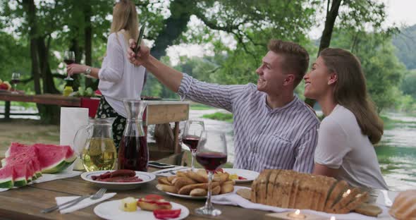 Young Happy Couple Taking Selfie While Having Picnic French Dinner Party Outdoor During Summer alt