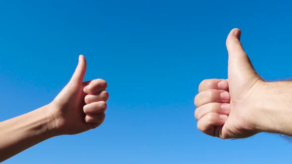 Hand Gestures Close-up. Male and Female Hands Thumbs Up Against the Blue Sky, OK, Good, Great. alt