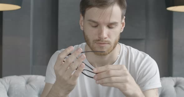 Close-up Portrait of Tired Caucasian Man Taking Off Eyeglasses and Rubbing Temples alt