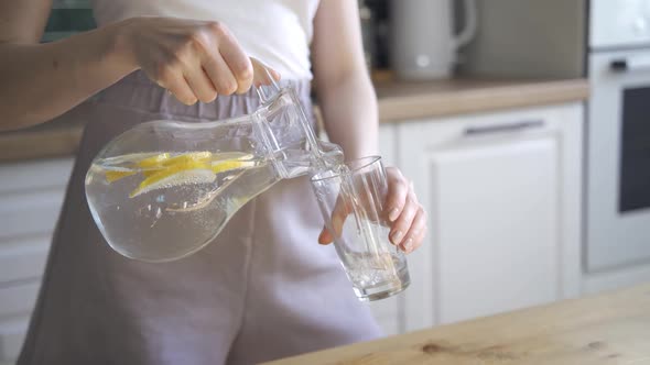 Beautiful Slim Woman Drinks Lemon Water for Detox alt