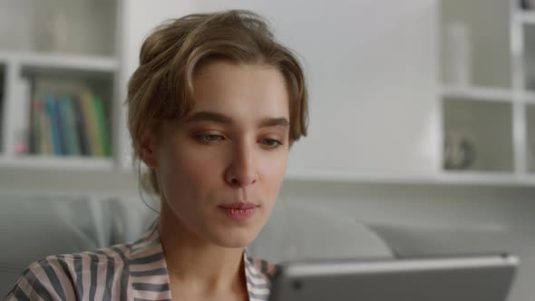 Serious Woman Browsing Internet Online Biting Lips in Living Room Close Up alt