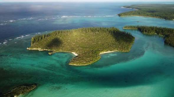 Aerial pan across small island near Oro Bay, Isle of Pines, highlighted with sunlight alt