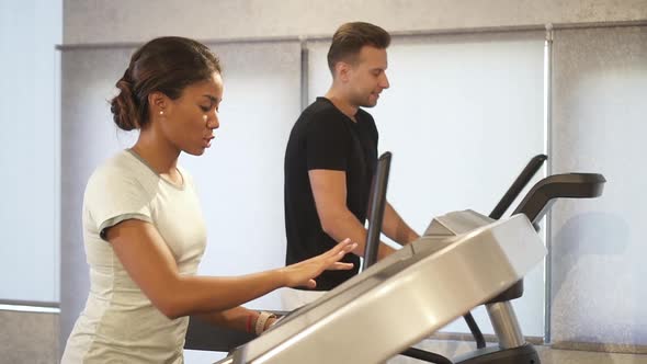 Woman and Man Running on Treadmill Machine alt