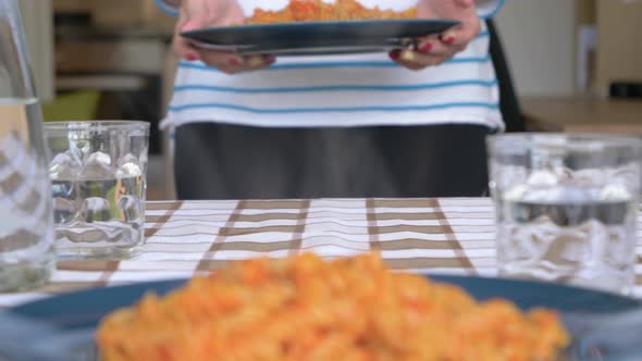 Slow motion shot of young woman serving pasta