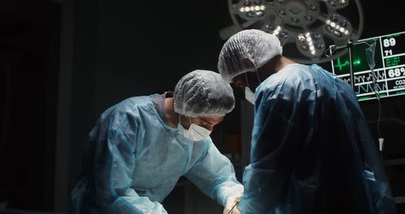 A Team of Surgeons Perform an Operation in a Bright Operating Room alt