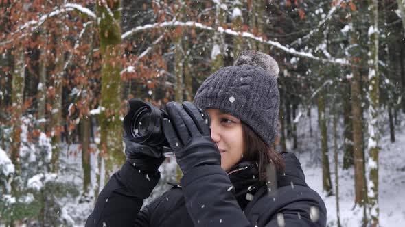 Beautiful woman do nature photography in forestry area during snowfall alt