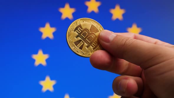 Symbolic bitcoin coin in hand in front of EU flag background