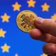 Symbolic bitcoin coin in hand in front of EU flag background - VideoHive Item for Sale