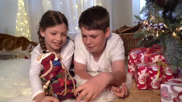 Festive Christmas scene indoors with happy children playing with father Xmas sleigh