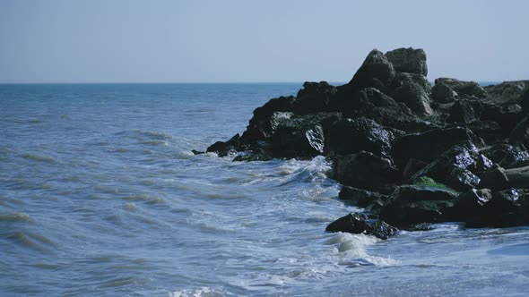 Waves hitting some rocks on the seashore alt
