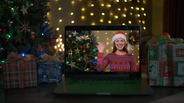 Smiling Woman with Santa Hat on a Videocall She is Happy and Wishing a Merry Christmas Online