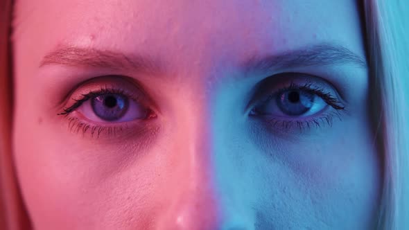 Female Blue Eyes in Neon Light Closeup