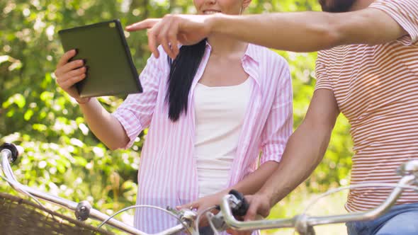 Couple with Tablet Pc and Bicycles at Summer Park alt